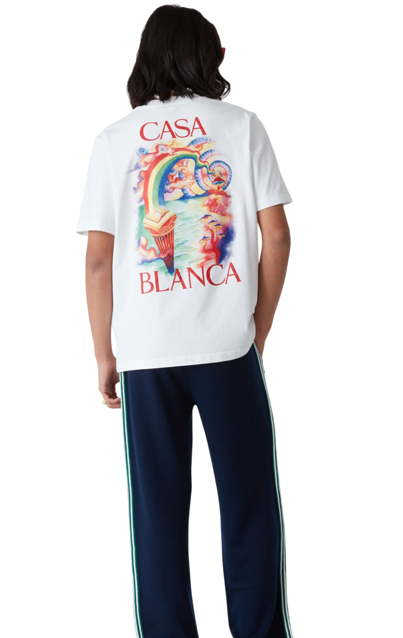 Person wearing a white Casa Blanca t-shirt featuring colorful artwork and a classic crew neck.